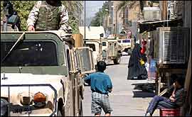 Boy walking past army vehicles