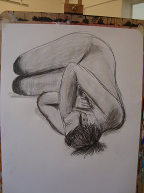 Life drawing of model curled into ball
