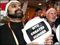 'Dünya Ticaret Örgütü açlık yaratıyor' yazılı bir döviz taşıyan bir eylemci