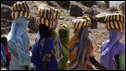 Darfuri women return to a UN refugee camp near Farchana, Chad