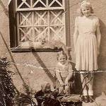 Mary (with doll's pram) with an older playmate at Nailsea during the war