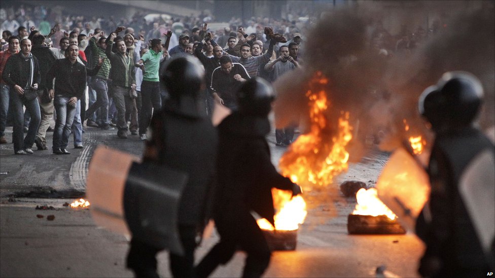Protestors face riot police in the streets.