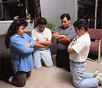 Four Mormons kneel in prayer