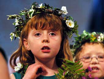 Un o ferched y ddawns flodau yn y Seremoni Coroni.