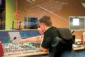 A man using a mixing desk in a sound gallery