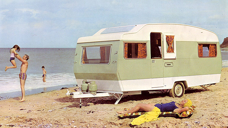Family on a beach on holiday with their caravan
