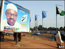 A woman walks past a billboard featuring presidential candidate of Congress for Progressive Change (CPC) Muhammadu Buhari in Kaduna Tuesday, March 1, 2011. 