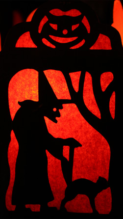 Silhouette of a witch and a cat in a stained glass window pane